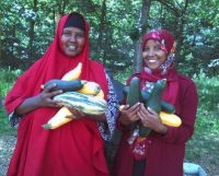 Photograph of two women holding produce