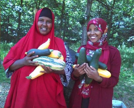 Photograph of two women holding produce