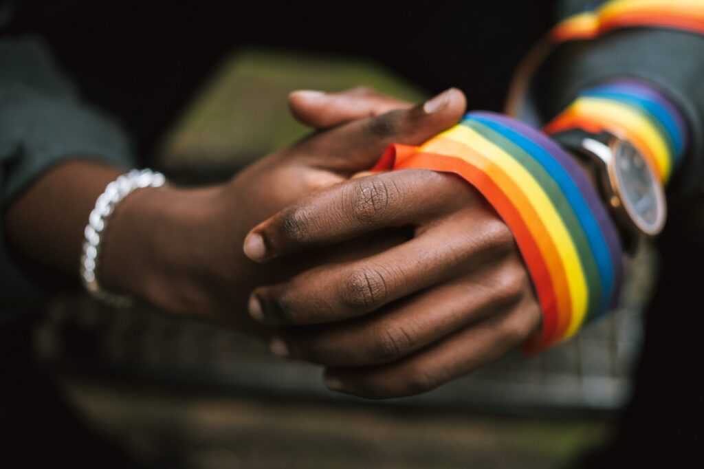 Photograph of hands holding LGBT ribbon