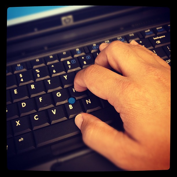 Photograph of hands on a computer